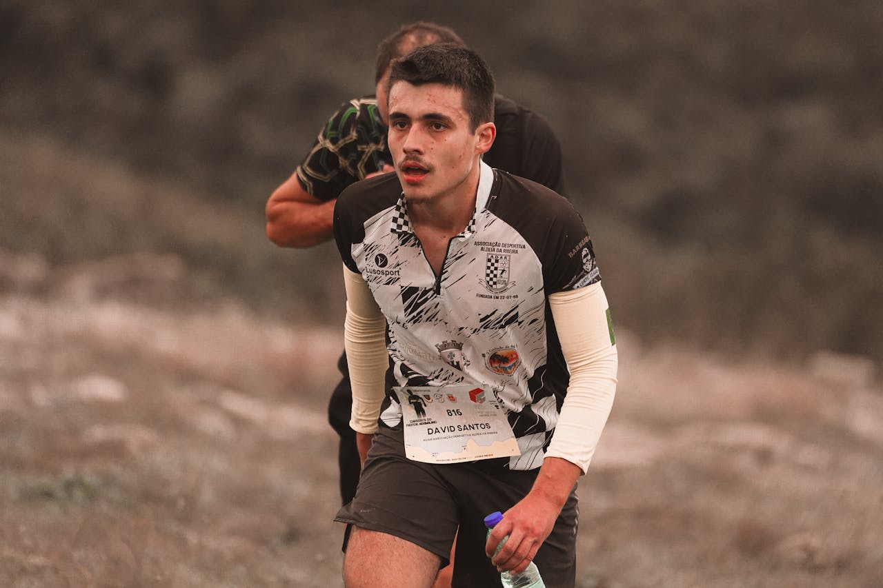 A young male athlete making an effort during an outdoor running competition.